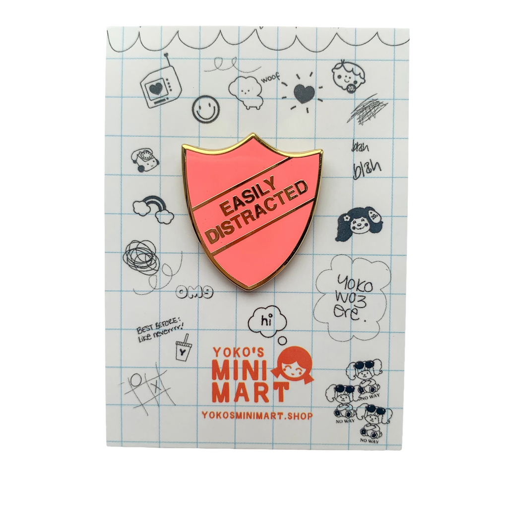 Pin with 'Easily Distracted' design on a card with doodles, featuring Yoko Mini Mart branding.