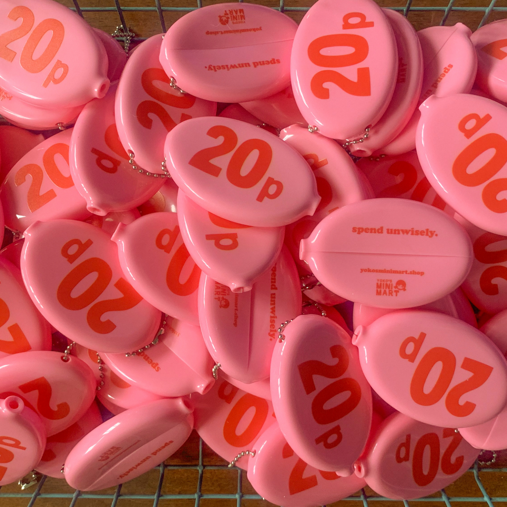 Collection of pink coin pouches with '20p' printed on them, arranged on a grid surface.